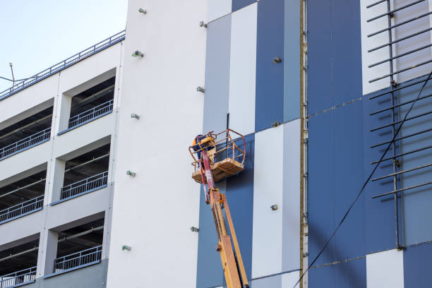 a man inside a lift is painting the side of a building2176373260