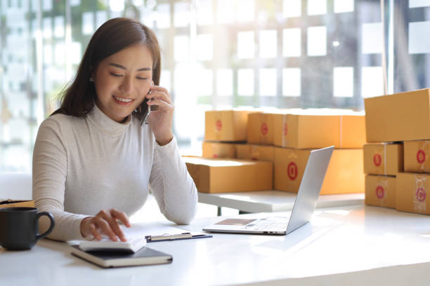 a young woman e commerce online small start up business owner calls with a partner and uses a1390671291